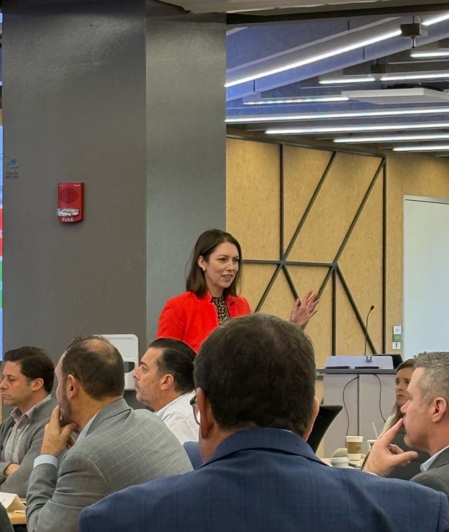 Meg Moriarty leading a leadership development session with a seated group of executives